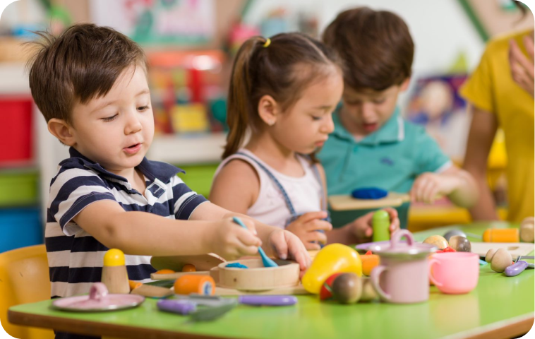 Pre-school students play with kitchen-themed toys in their early learning classroom.